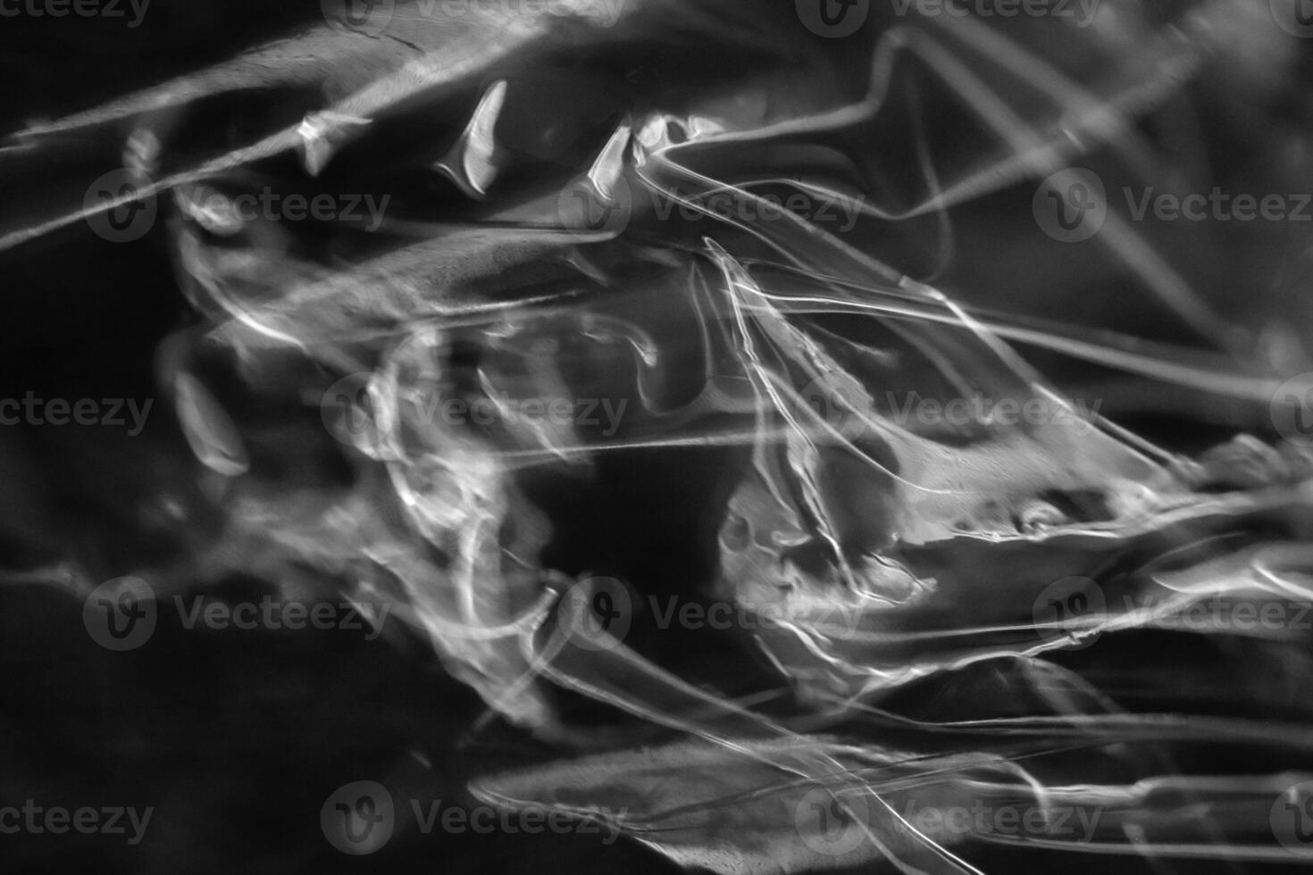 Drawing of the glowing rays of the sun on crumpled cellophane. Black and white. Filling background. photo