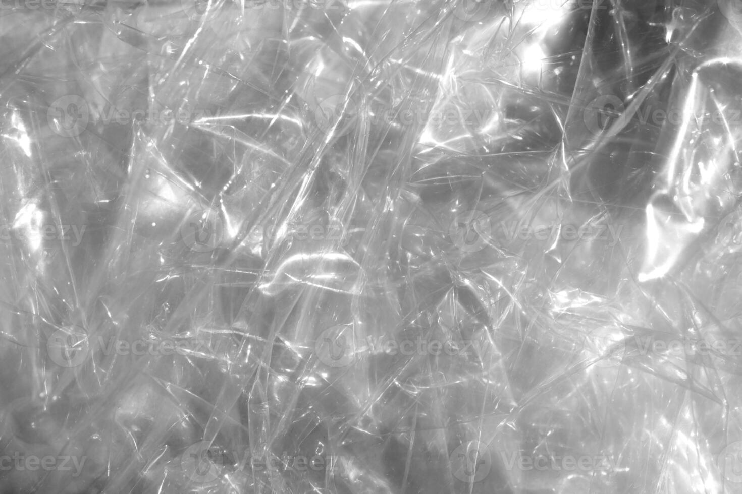 Crumpled cellophane texture. Plastic light reflection filling background. photo