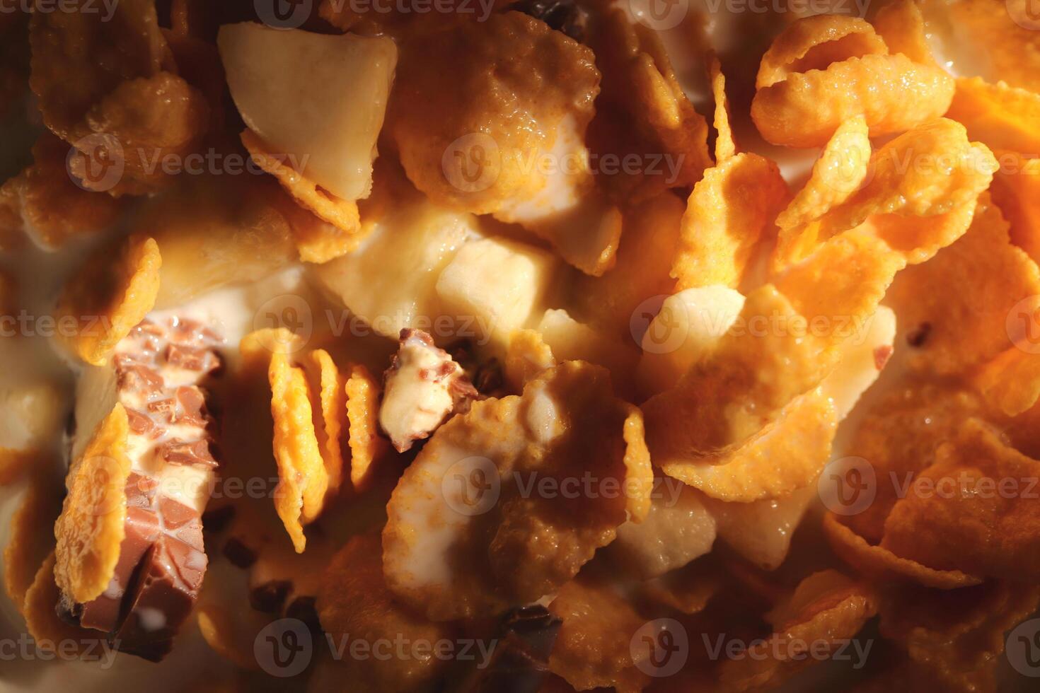 Cornflakes with chocolate sliced banana and milk in sun light. Filling background. Macro close-up. photo