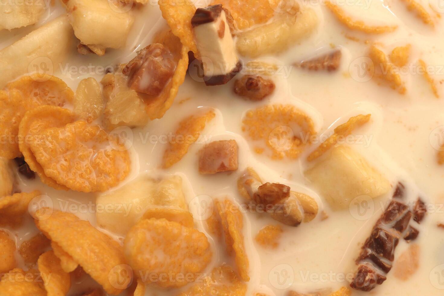 Cornflakes with chocolate sliced banana and milk. Filling background. Macro close-up. photo
