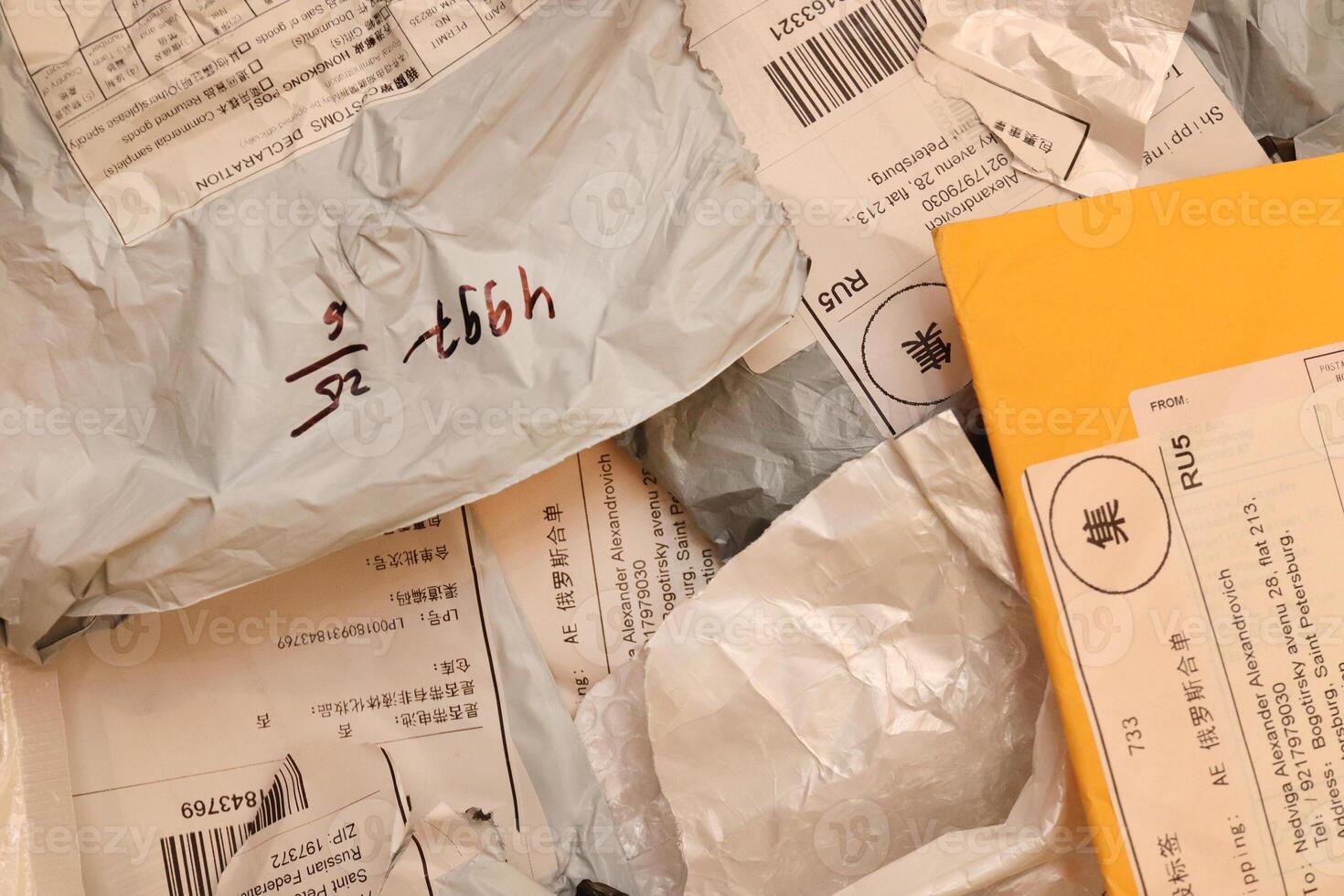 Many post packets and one yellow with labels filling background. photo