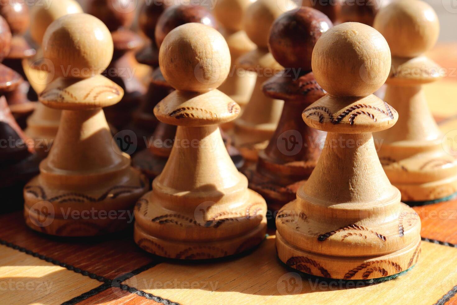 Many white and black pawns figures stand on a chess board. Wood game chessboard background. photo