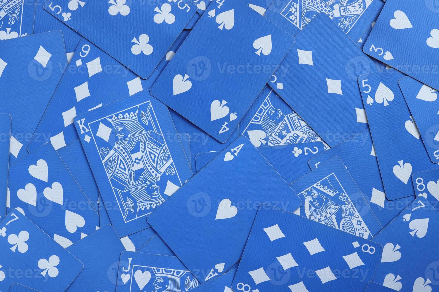 Mixed playing cards background. Assorted play cards backdrop. Many miscellaneous jumbled blue playing cards surface. photo