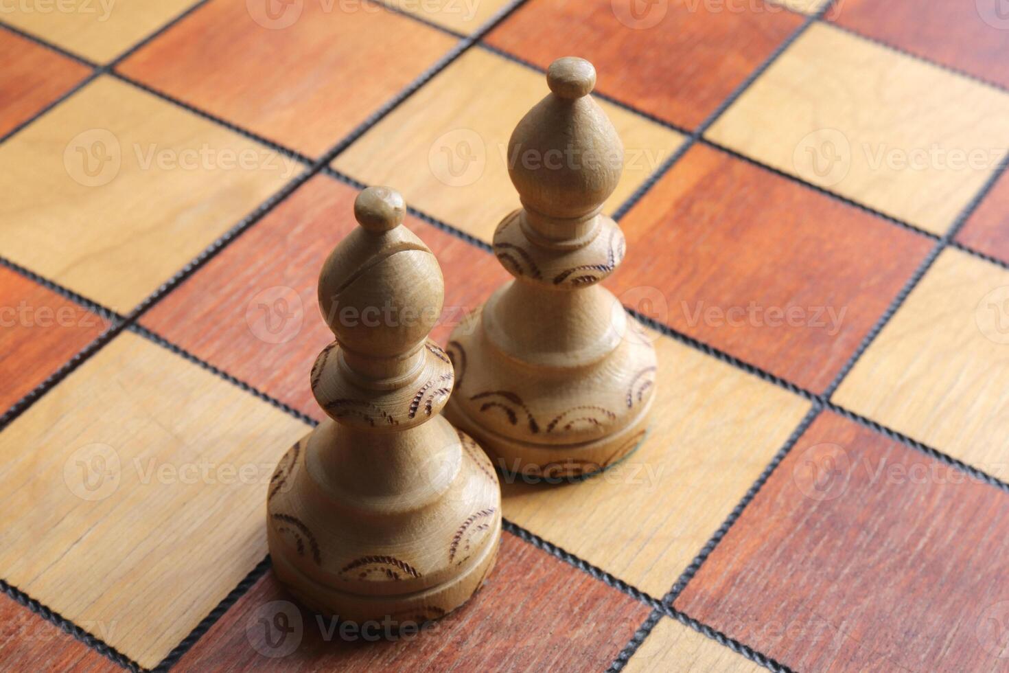 Two white elephants figures stands on a chessboard. Chess figures background. Wood game chessboard. photo