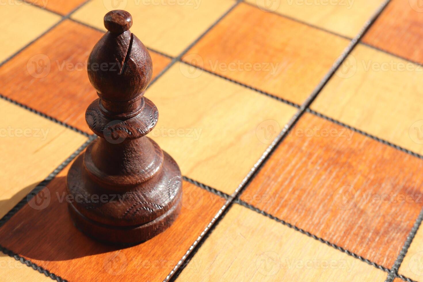 The figure of a black elephant stands on a chess board. Wood game chessboard background. photo