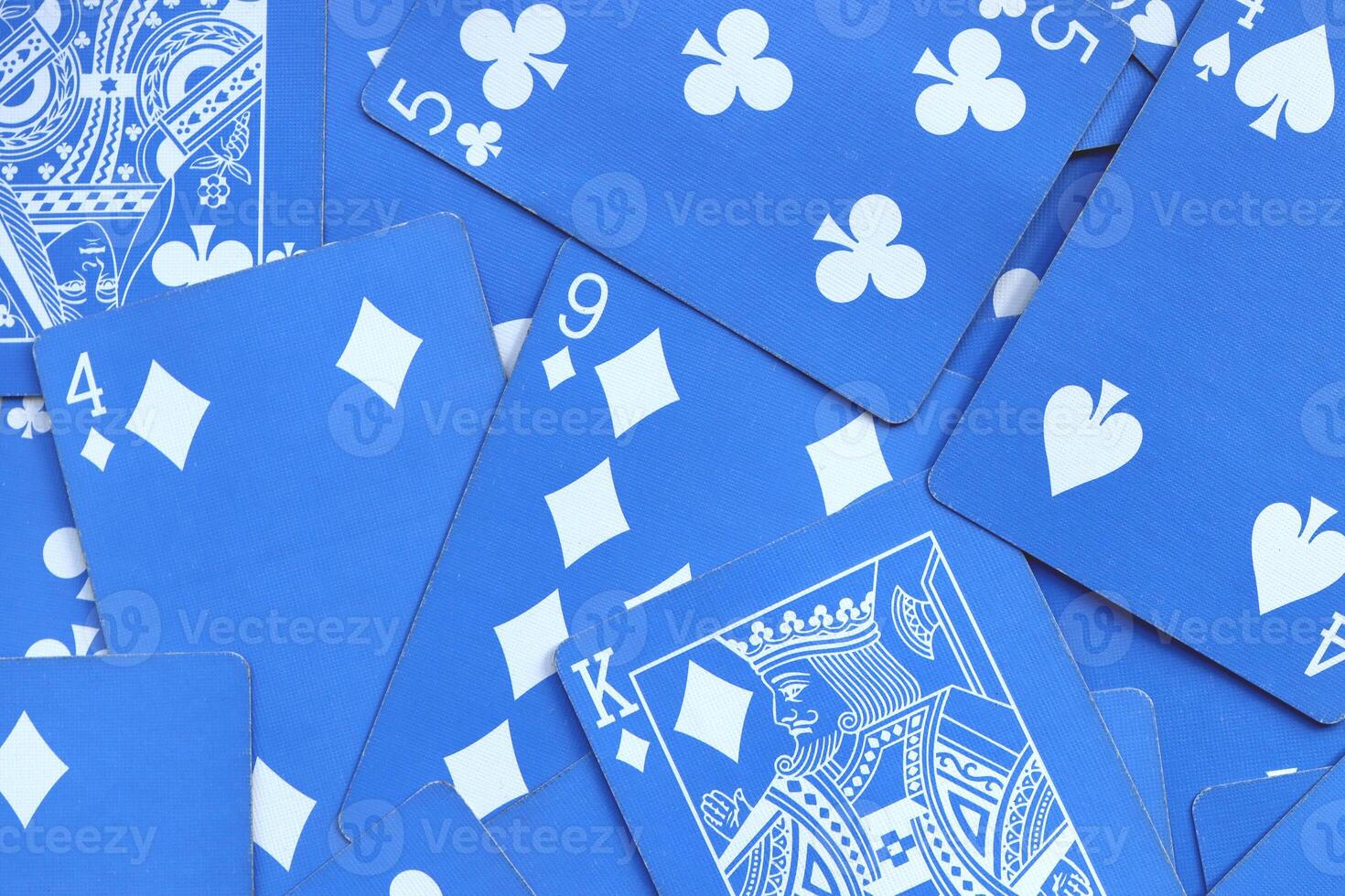 Assorted play cards backdrop. Many miscellaneous jumbled blue playing cards surface. Mixed playing cards background. photo
