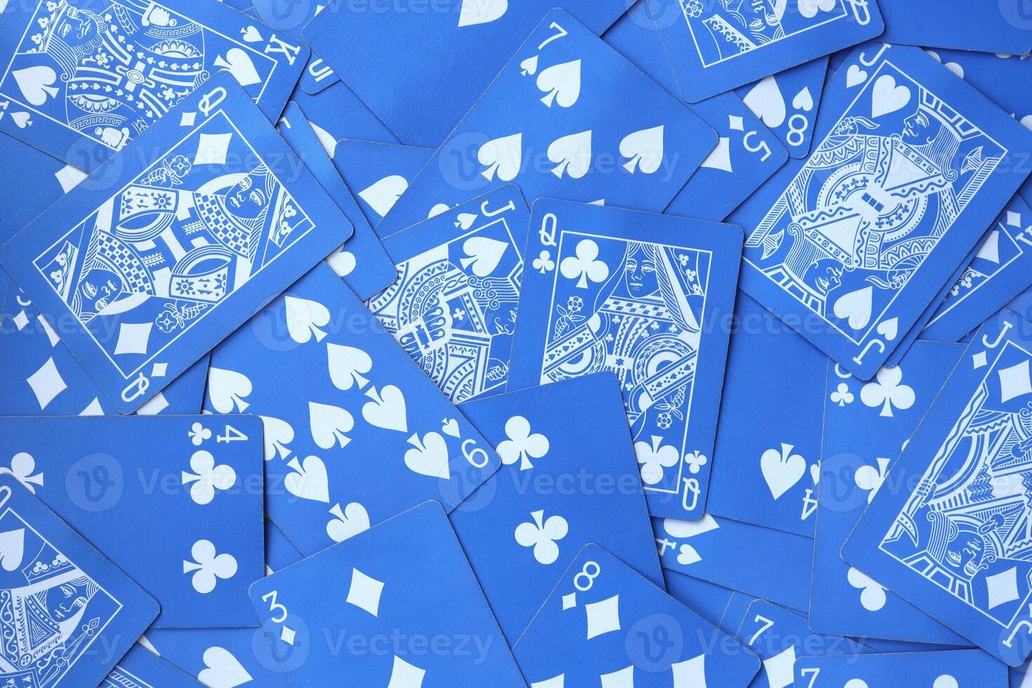 Assorted play cards backdrop. Many miscellaneous jumbled blue playing cards surface. Mixed playing cards background. photo