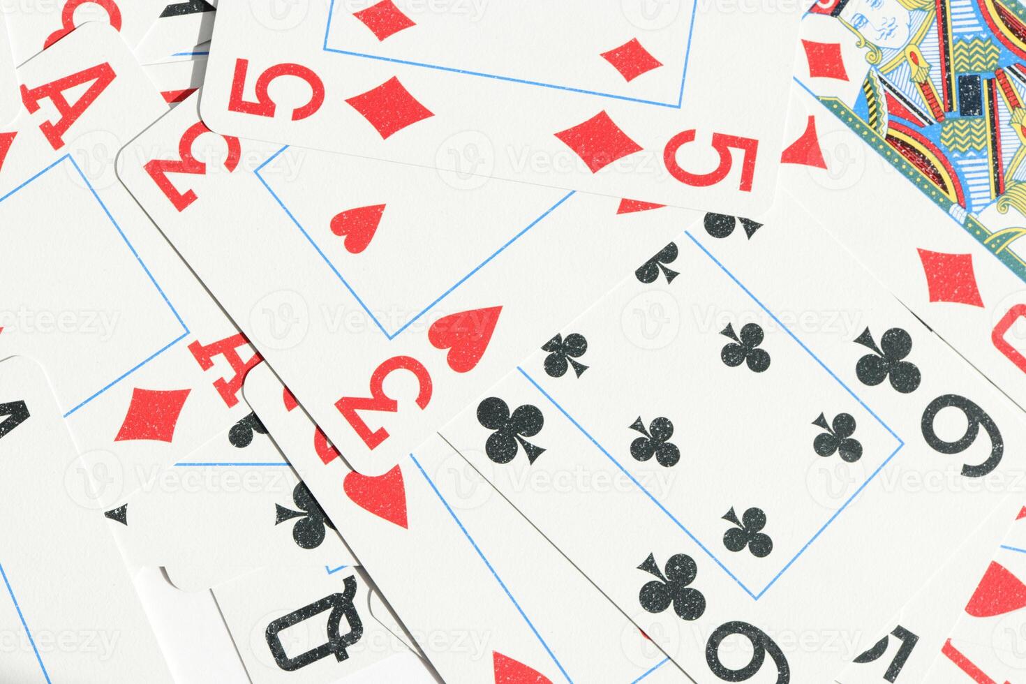 Many miscellaneous jumbled playing cards surface. Mixed playing cards background. Assorted play cards backdrop. photo