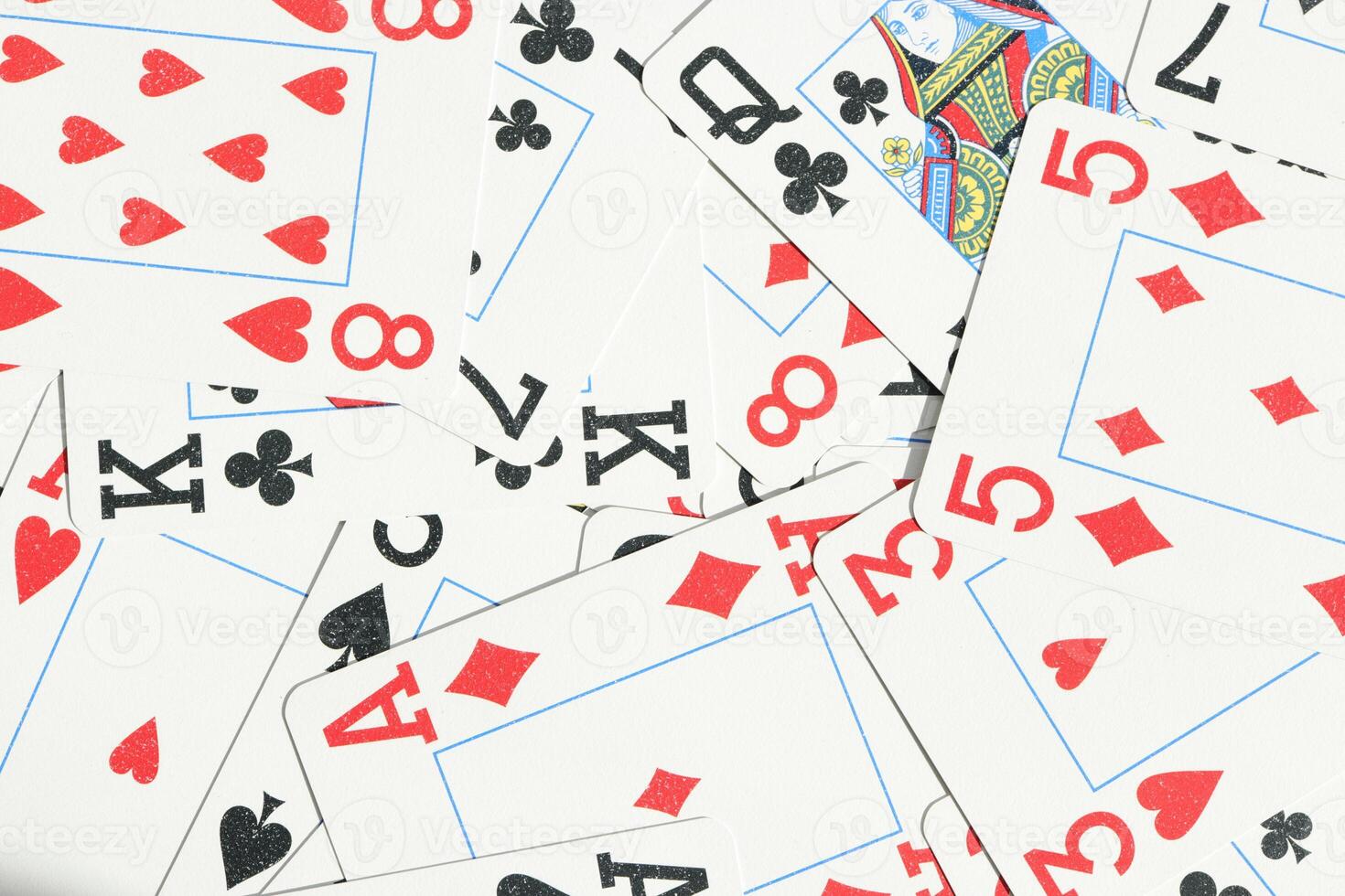 Assorted play cards backdrop. Many miscellaneous jumbled playing cards surface. Mixed playing cards background. photo
