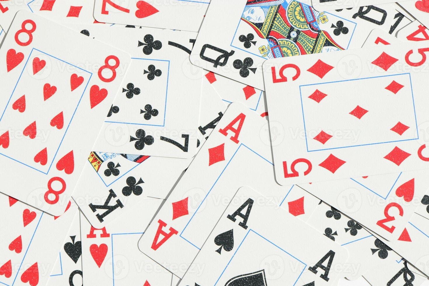 Assorted play cards backdrop. Many miscellaneous jumbled playing cards surface. Mixed playing cards background. photo