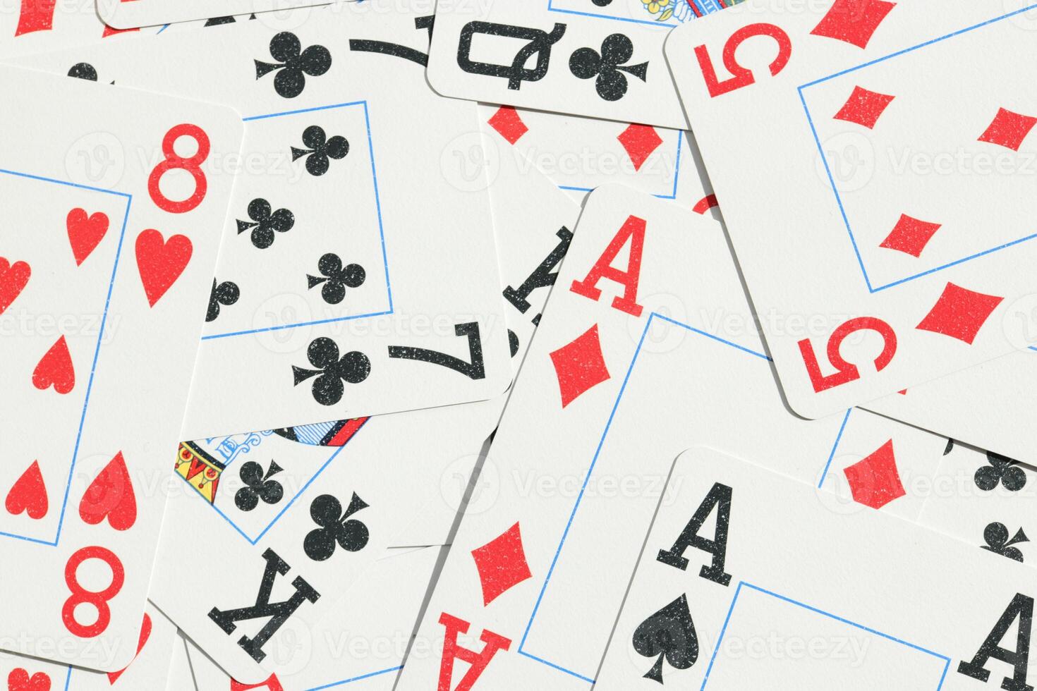 Many miscellaneous jumbled playing cards surface. Mixed playing cards background. Assorted play cards backdrop. photo