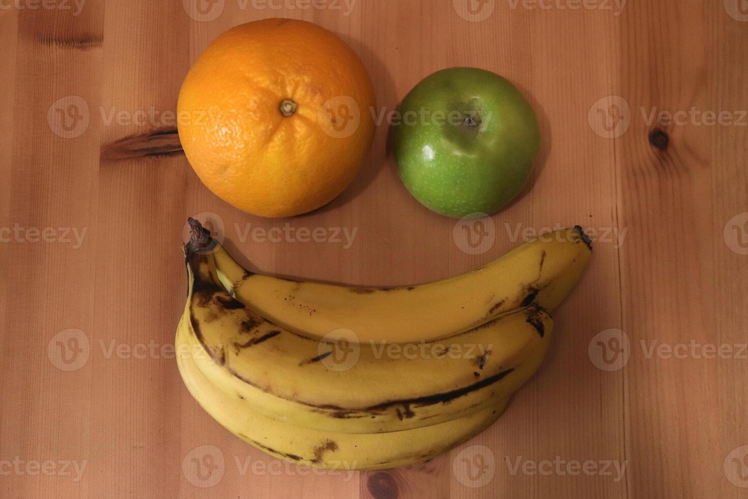 Banana with orange and apple on the table photo