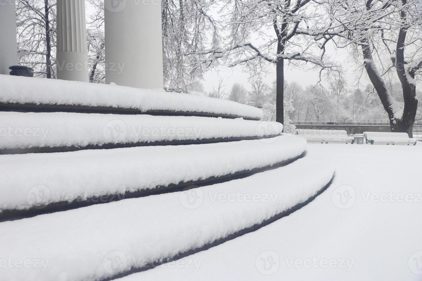 Pavilion under the flag round steps under a thick layer of snow. Landscape of winter park. photo