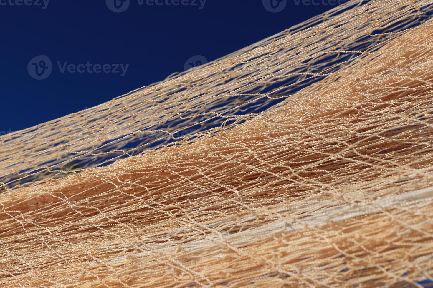 Nylon fishnet texture on the clear sky. Nautical marine background. Macro closeup. photo