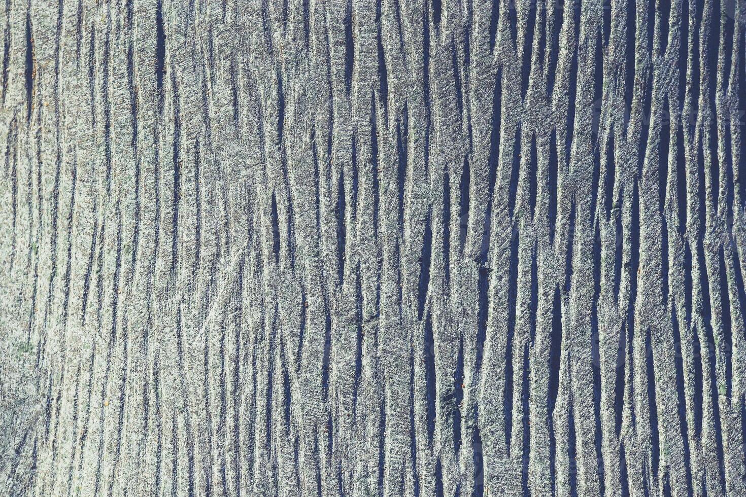 Sawn lot of cross dashes blue granite wall texture. Granite surface background. photo