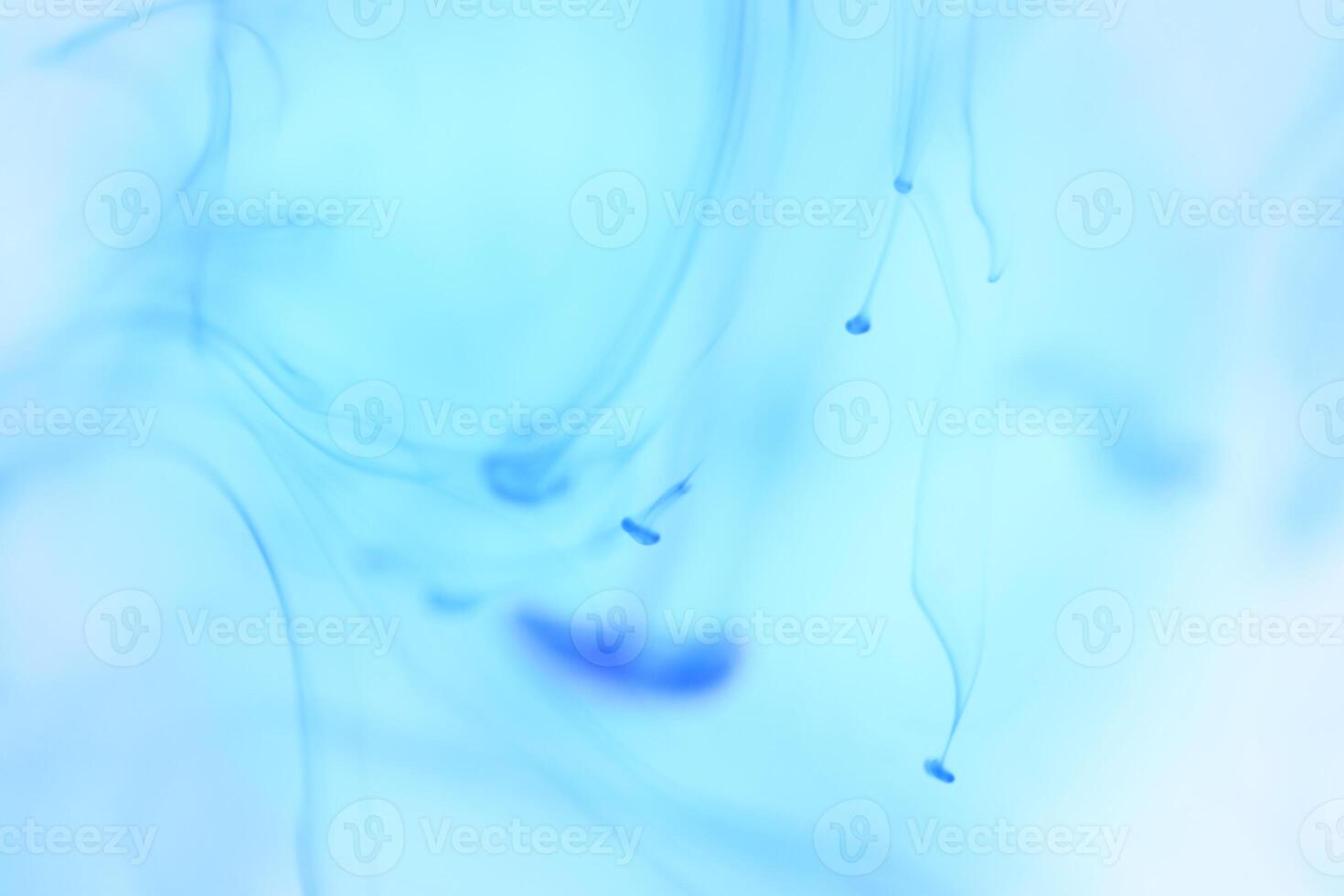 Blue Ink Drips in Clear Water. Soft Ambient Background. photo