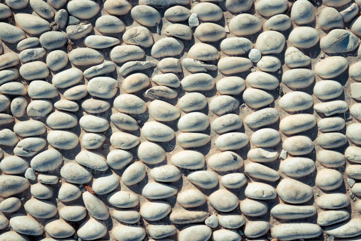 Stones pattern background. Lot of white masonry cladding pebble texture. photo