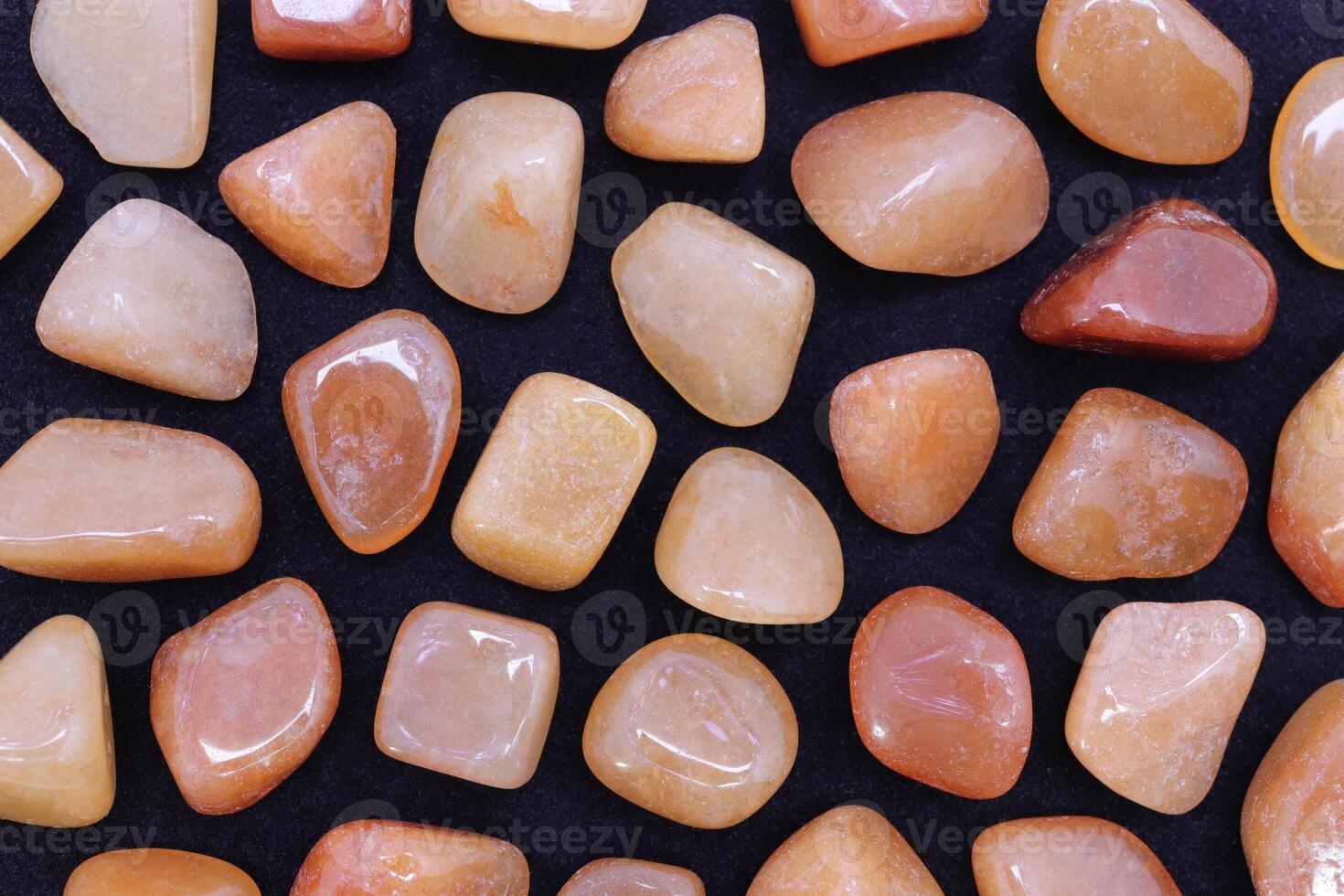 Red Aventurine rare jewel texture on black background. Sparse mineral pebbles backdrop. photo