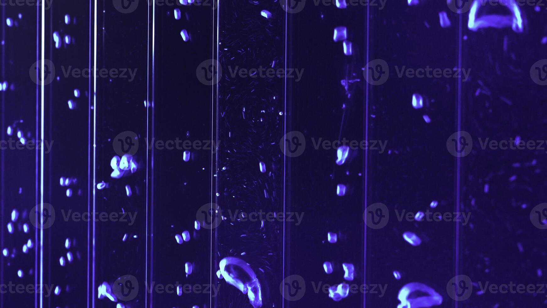 Close up of underwater view of air bubbles in colored liquid substance. Clip. Vertical bubbles flow in water. photo