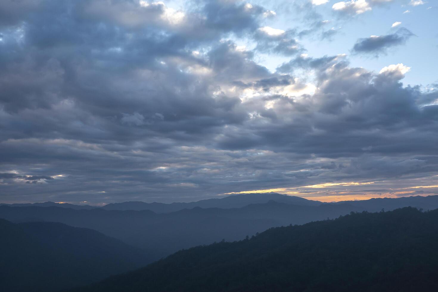 Mountain Sunset with Clouds, a Breathtaking Landscape Bathed in Evening Light and Mist, Capturing the Beauty of Nature's Colors and Tranquil Atmosphere photo