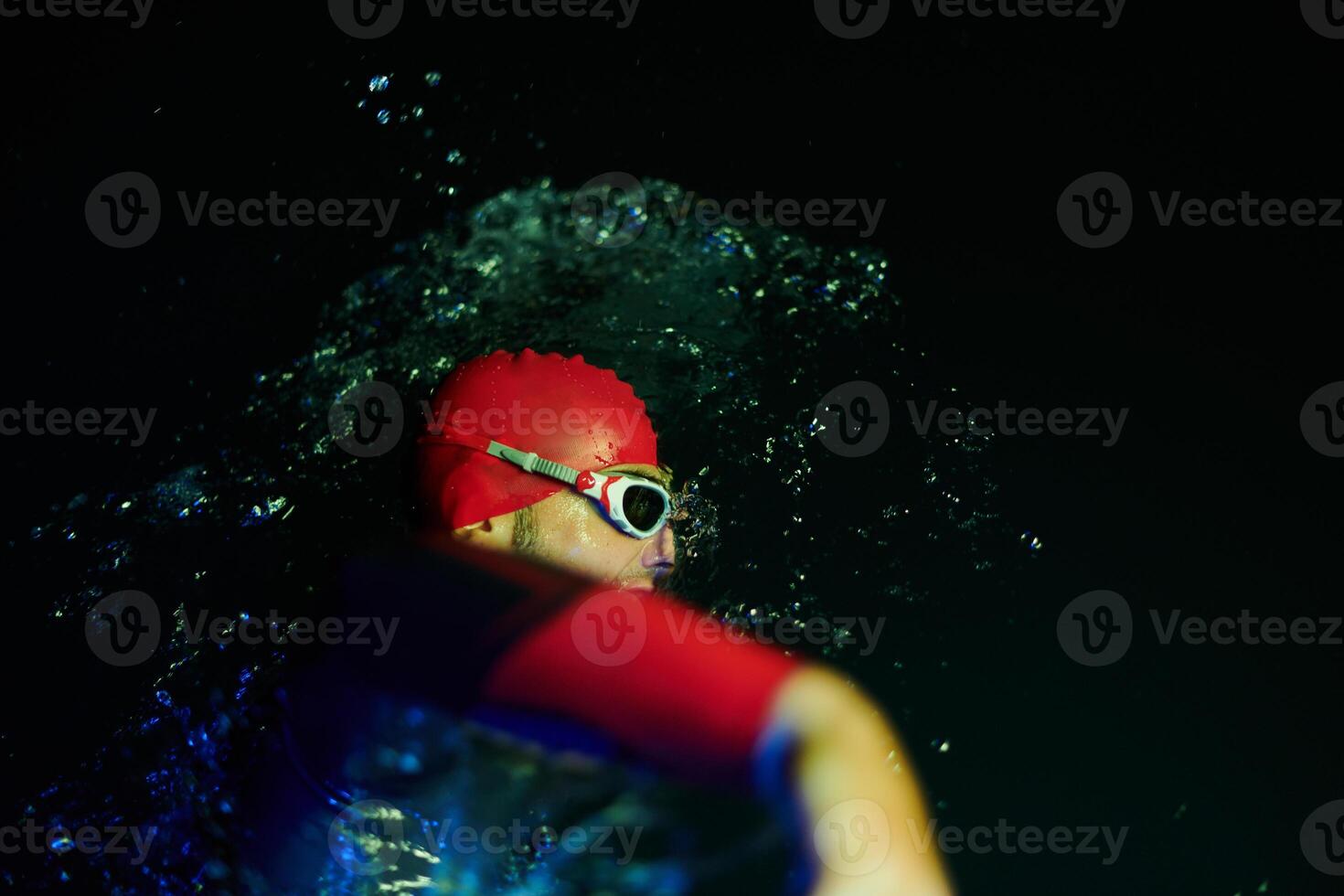 Authentic triathlete swimmer having a break during hard training on night neon gel light photo