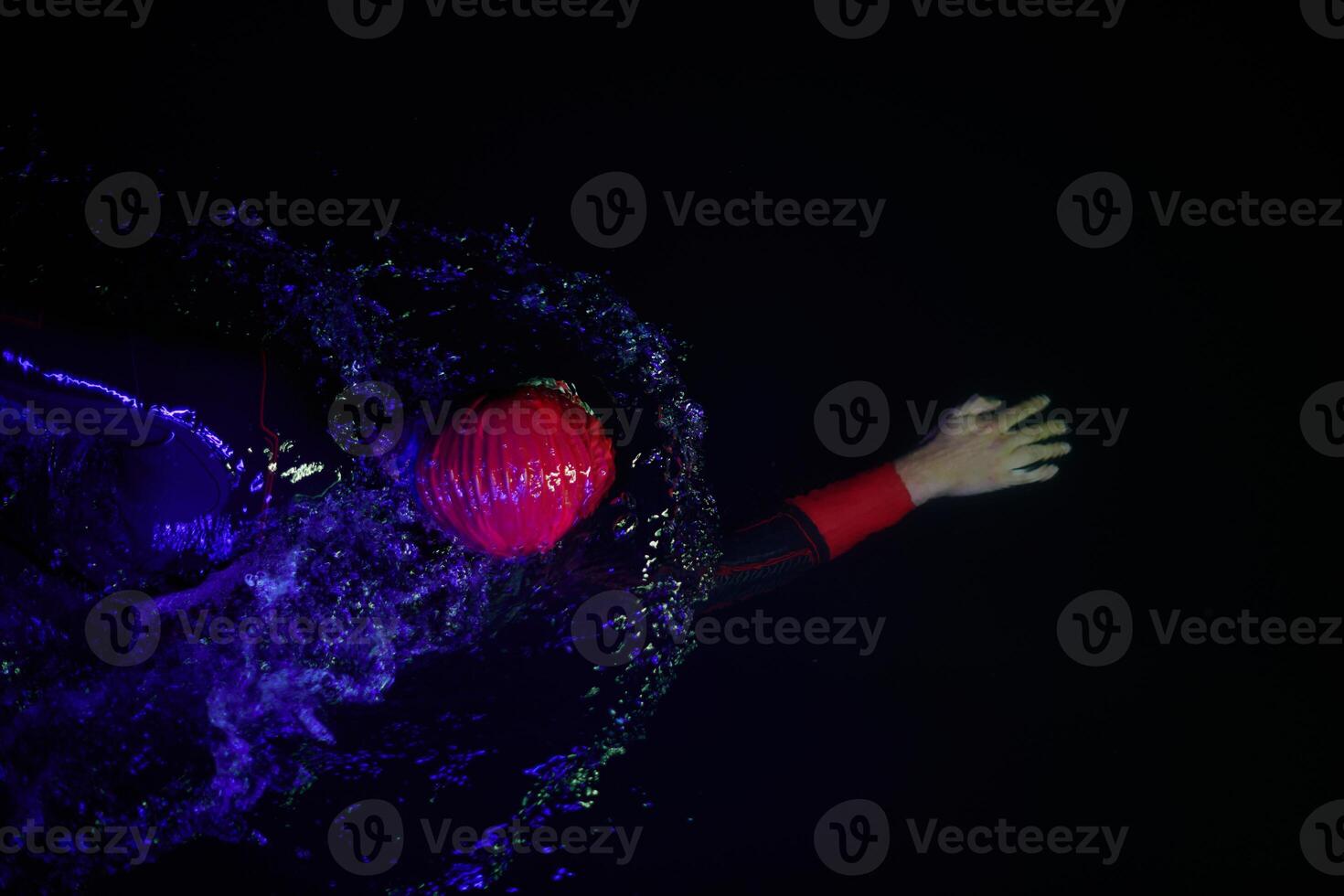 Authentic triathlete swimmer having a break during hard training on night neon gel light photo