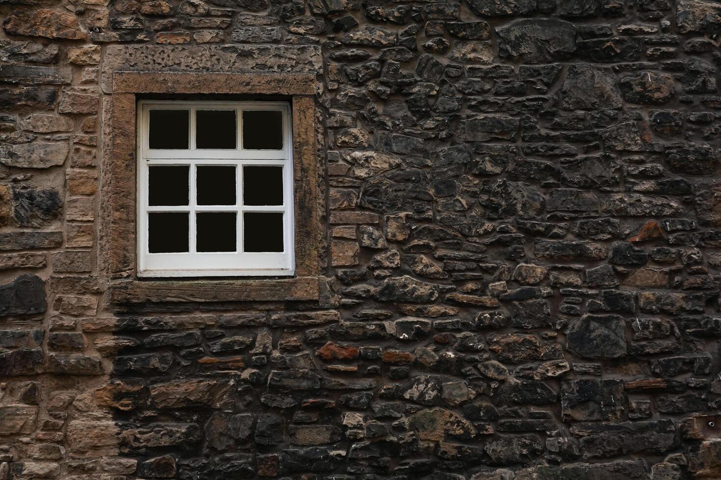 Vintage Window Embedded in Stone Wall of an Ancient House photo