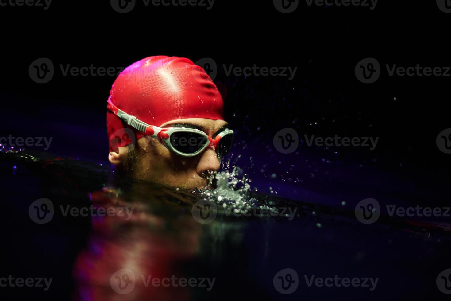 A determined professional triathlete undergoes rigorous night time training in cold waters, showcasing dedication and resilience in preparation for an upcoming triathlon swim competition photo