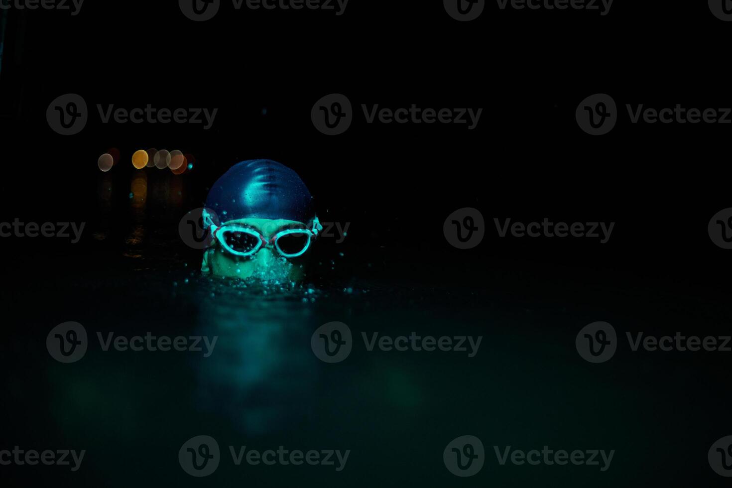 Authentic triathlete swimmer having a break during hard training on night neon gel light photo
