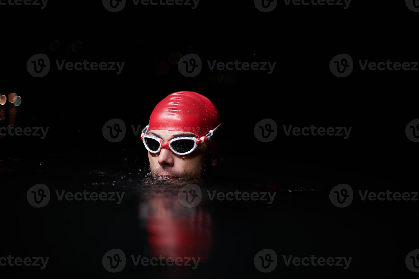 A determined professional triathlete undergoes rigorous night time training in cold waters, showcasing dedication and resilience in preparation for an upcoming triathlon swim competition photo