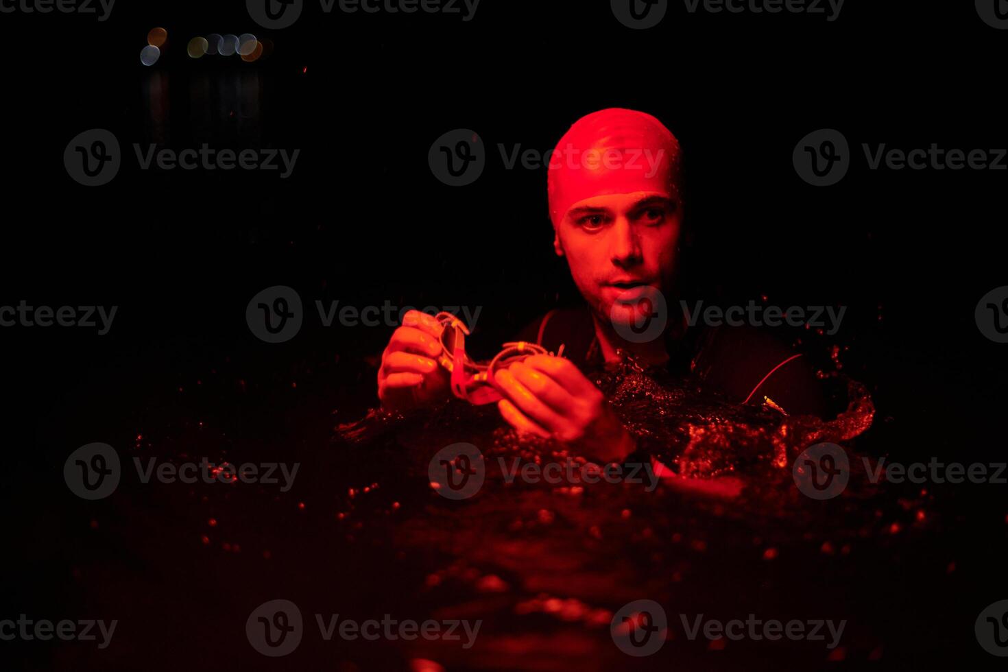 Authentic triathlete swimmer having a break during hard training on night neon gel light photo