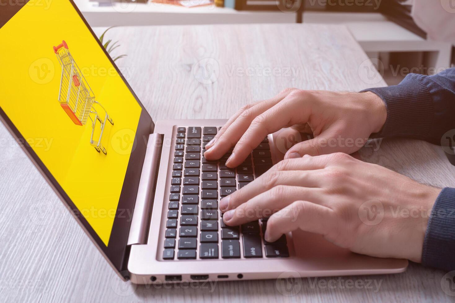 Hands typing on laptop keyboard with shopping cart on display. Concept image of online shopping. Modern digital retail experience photo
