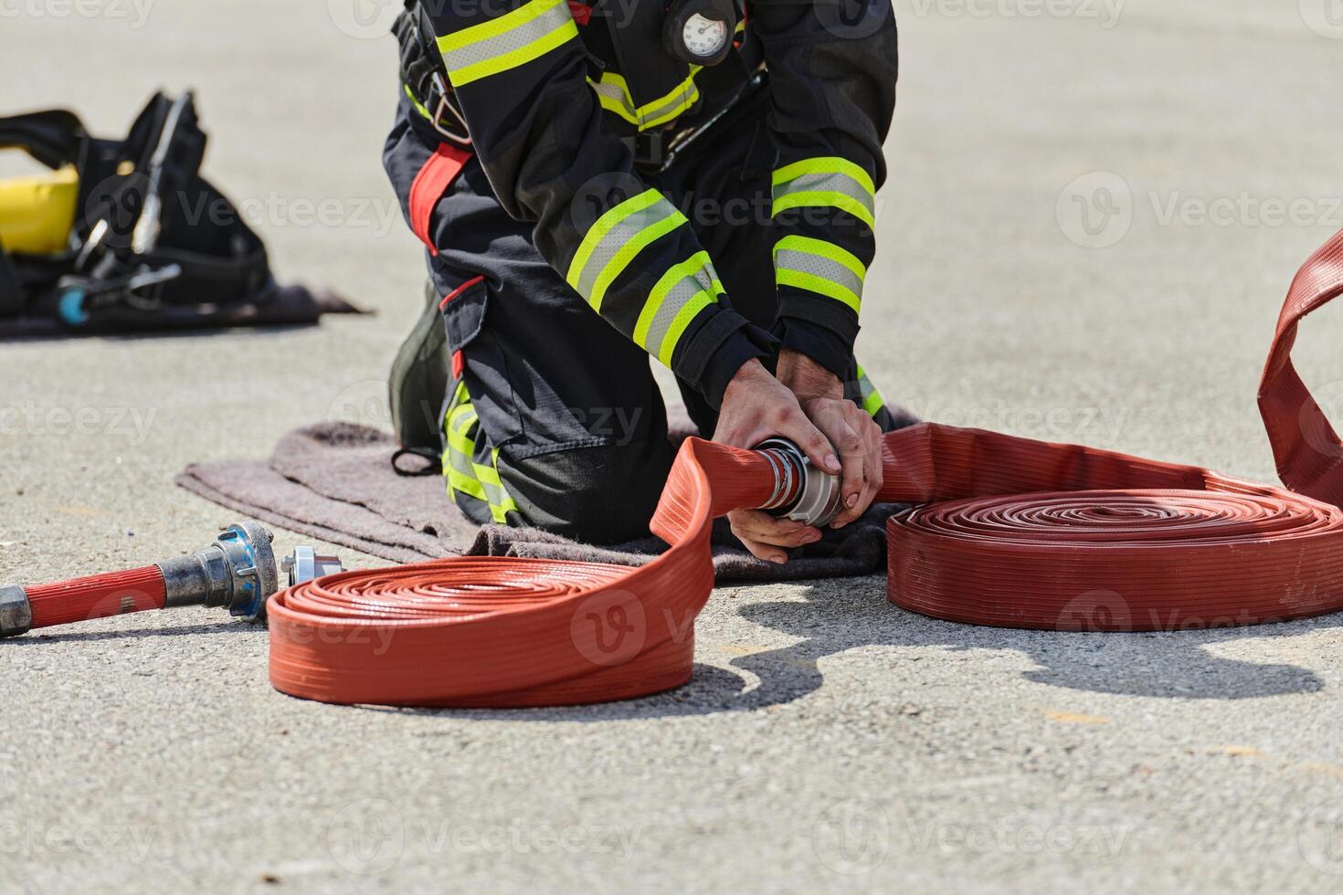 A firefighter dons the essential components of their professional gear, embodying resilience, commitment, and readiness as they gear up for a hazardous firefighting mission, a testament to their photo