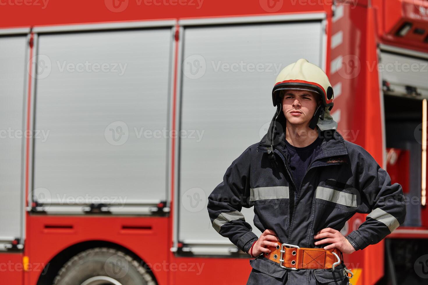Firefighter Stands Proudly with Professional Gear Beside Fire Truck After Intense Training photo