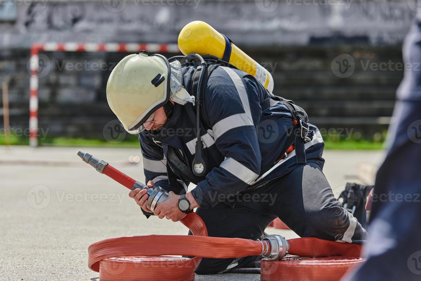 A firefighter dons the essential components of their professional gear, embodying resilience, commitment, and readiness as they gear up for a hazardous firefighting mission, a testament to their photo