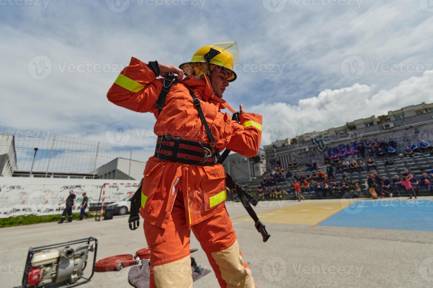 In a dynamic display of synchronized teamwork, firefighters hustle to carry, connect, and deploy firefighting hoses with precision, showcasing their intensive training and readiness for challenging photo