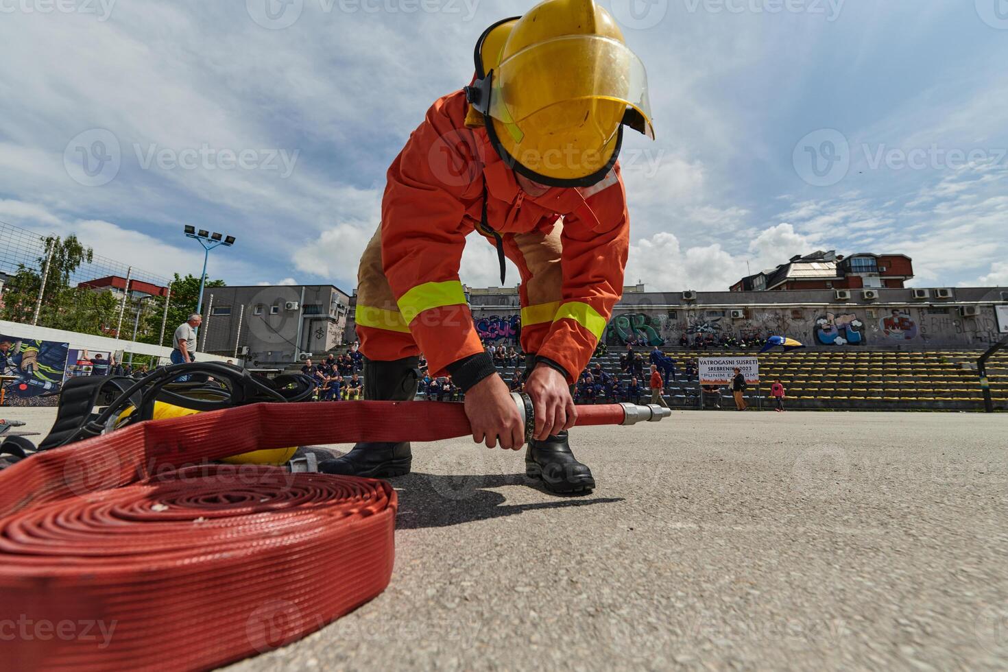 Professional Firefighter Cleaning Up Fire Hose After Extinguishing Blaze photo