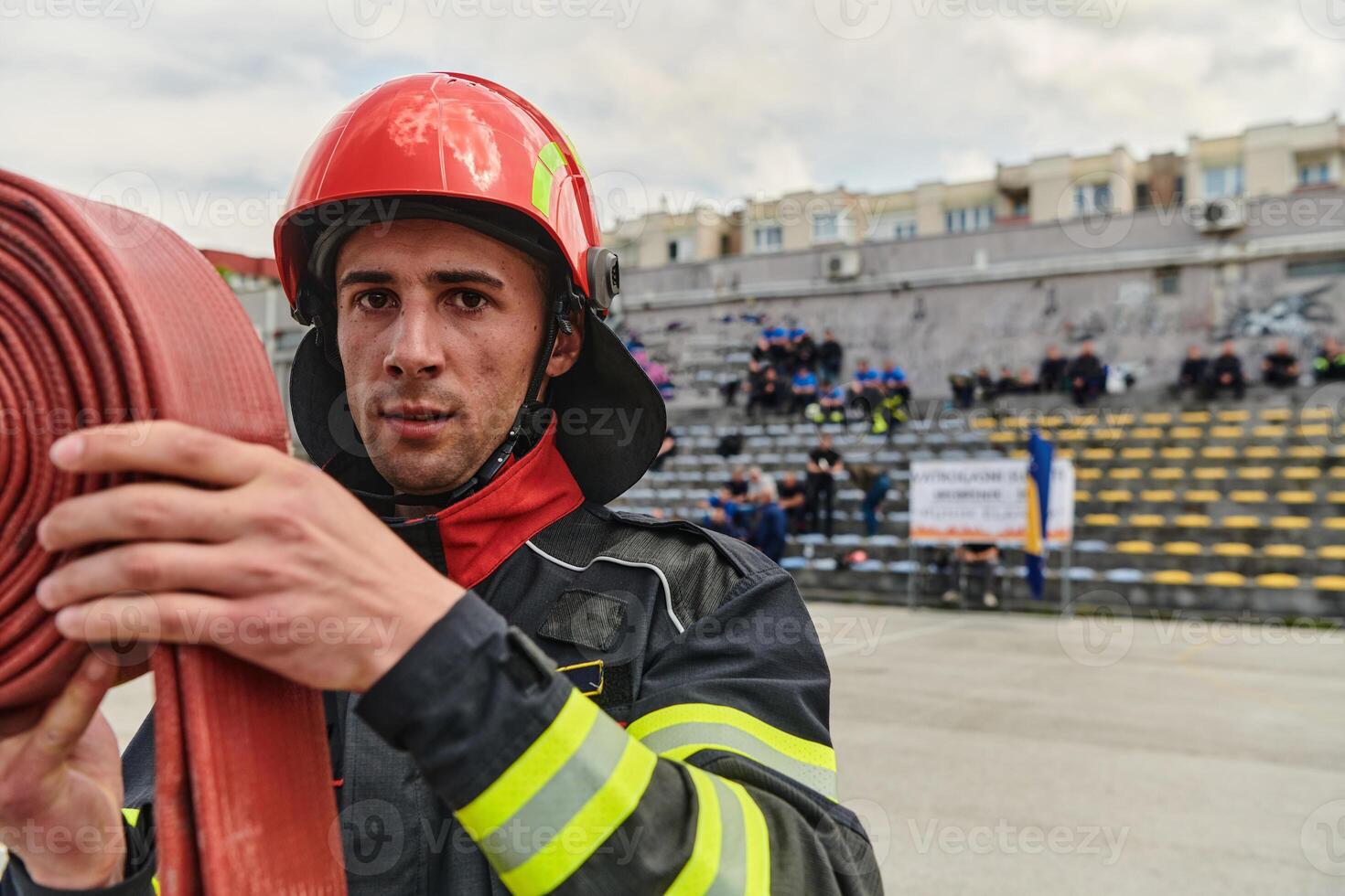 Professional Firefighter Cleaning Up Fire Hose After Extinguishing Blaze photo
