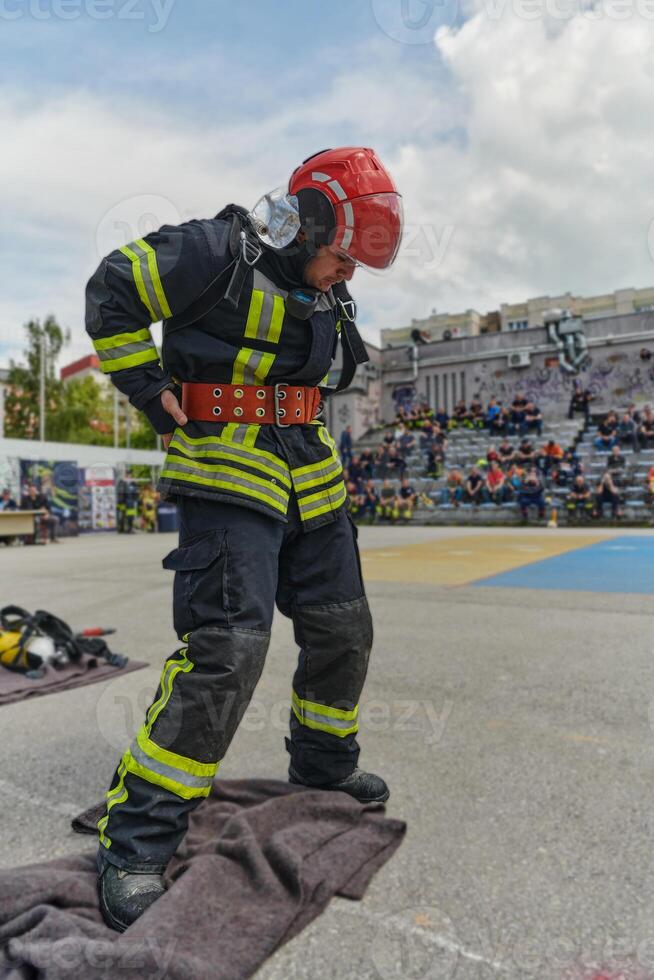 A firefighter dons the essential components of their professional gear, embodying resilience, commitment, and readiness as they gear up for a hazardous firefighting mission, a testament to their photo