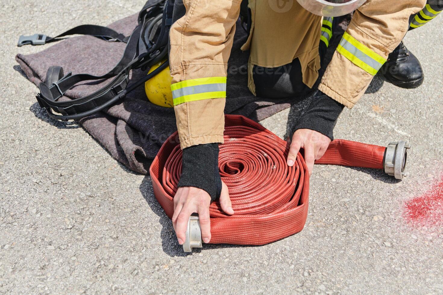 Professional Firefighter Cleaning Up Fire Hose After Extinguishing Blaze photo