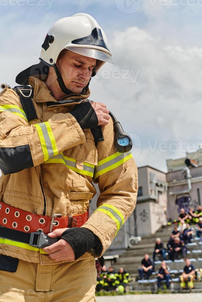 A firefighter dons the essential components of their professional gear, embodying resilience, commitment, and readiness as they gear up for a hazardous firefighting mission, a testament to their photo