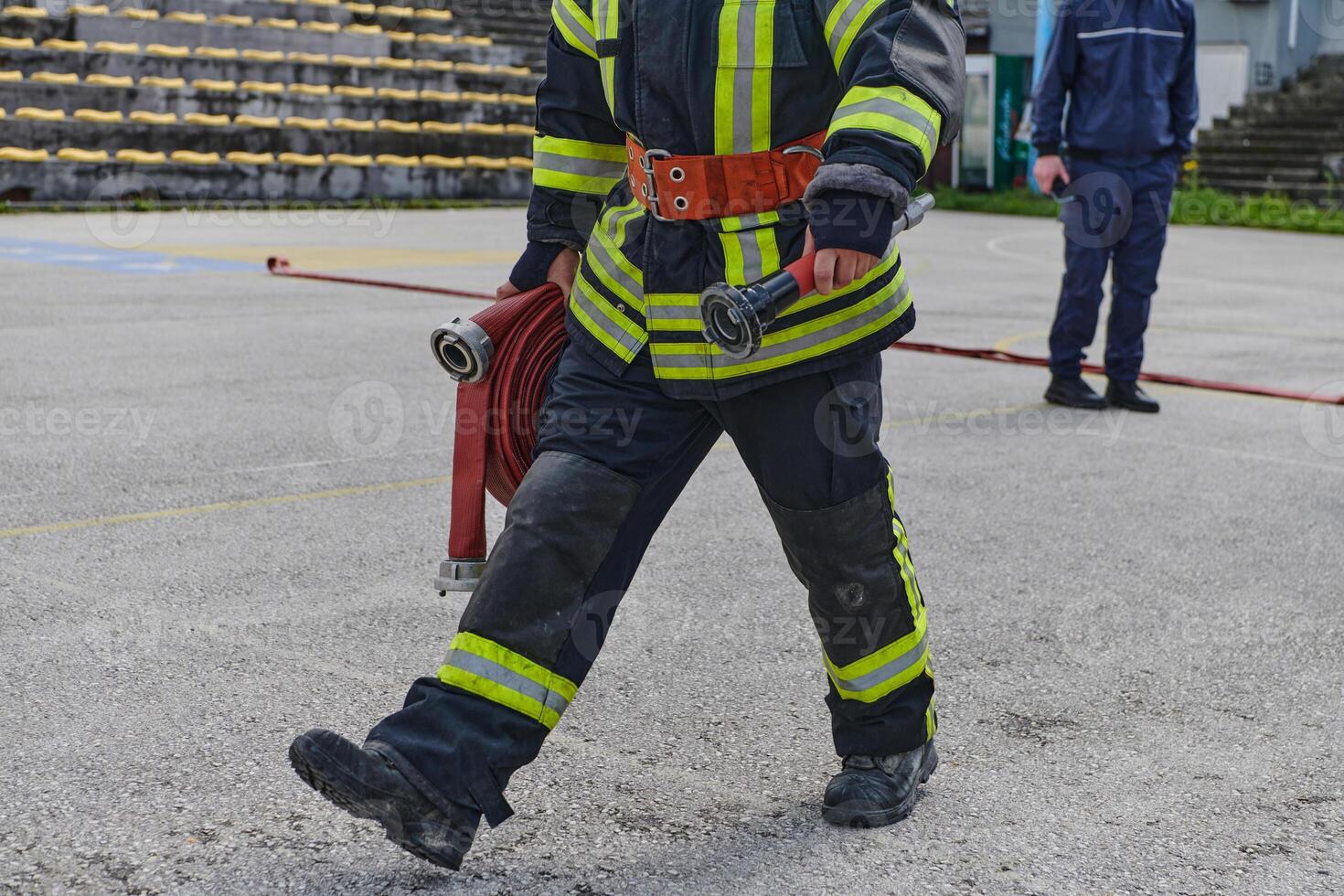 A firefighter dons the essential components of their professional gear, embodying resilience, commitment, and readiness as they gear up for a hazardous firefighting mission, a testament to their photo