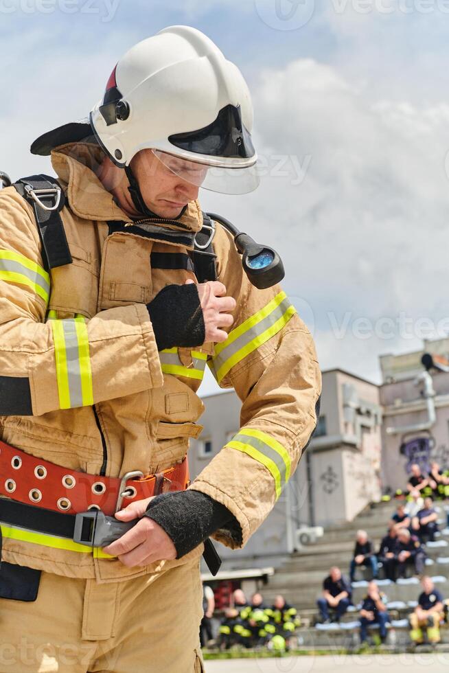 A firefighter dons the essential components of their professional gear, embodying resilience, commitment, and readiness as they gear up for a hazardous firefighting mission, a testament to their photo