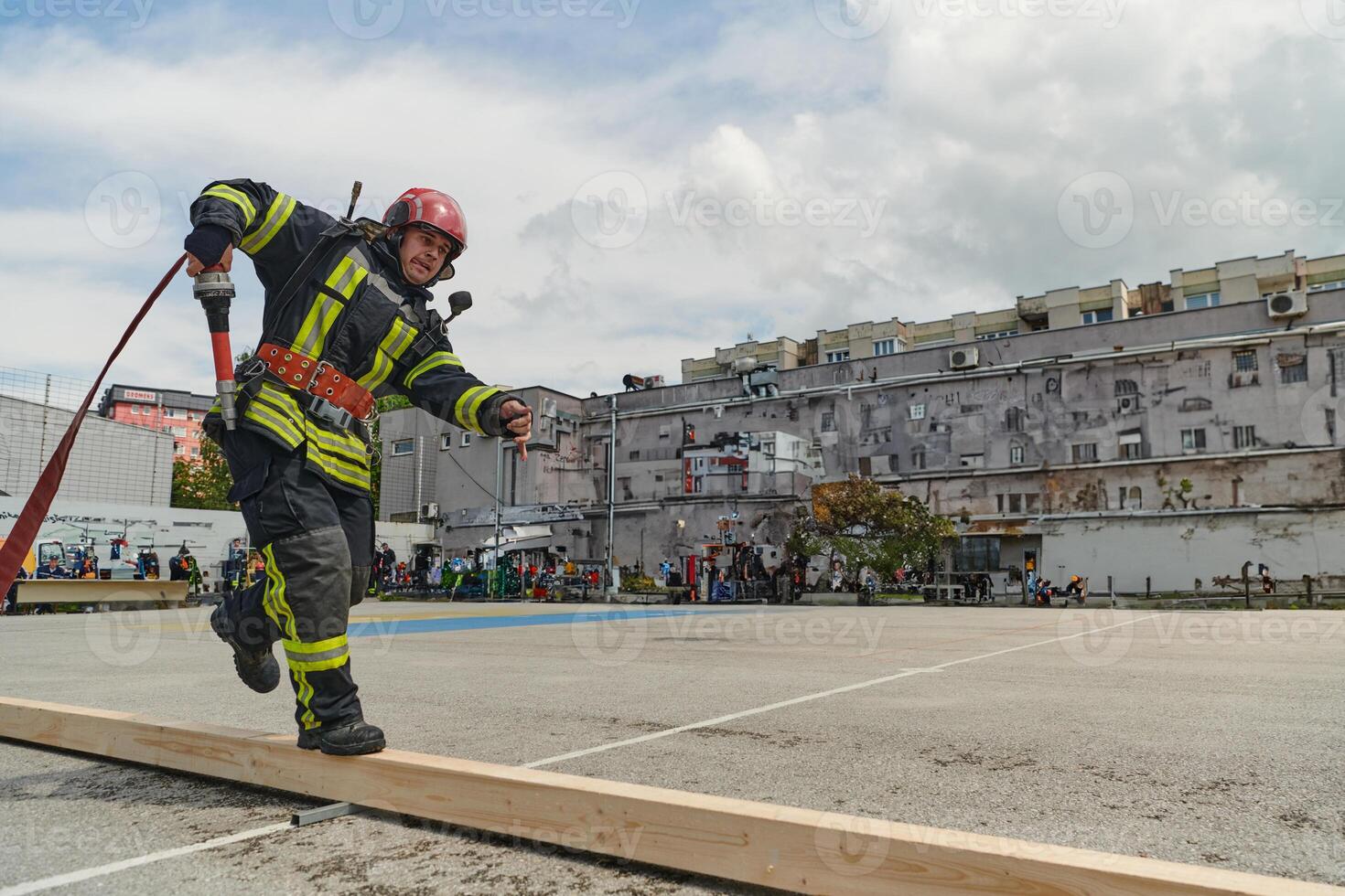In a dynamic display of synchronized teamwork, firefighters hustle to carry, connect, and deploy firefighting hoses with precision, showcasing their intensive training and readiness for challenging photo