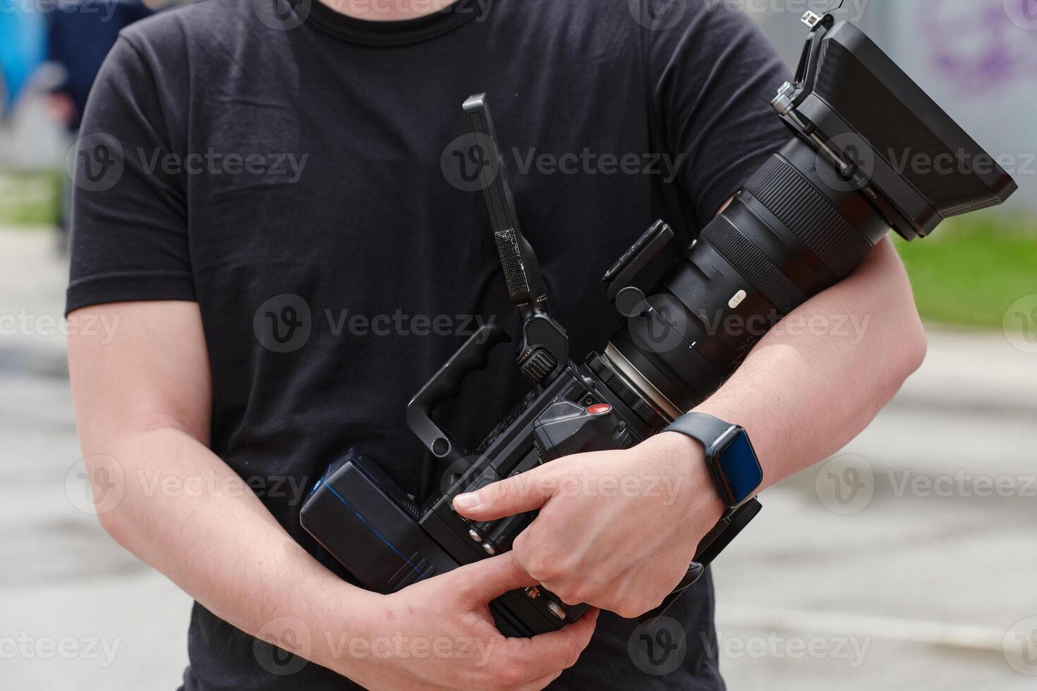 A skilled videographer, armed with professional equipment, adeptly captures outdoor events, demonstrating precision and creativity in cinematic storytelling through the lens of their camera photo