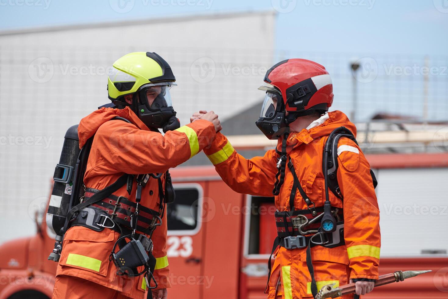 A unified team of firefighters, adorned in their uniforms, engages in a heartfelt celebration marked by triumphant salutes and cheers, embodying the joy and gratitude following the successful photo