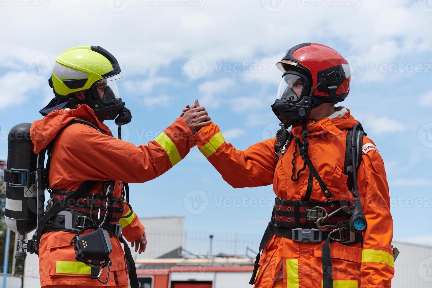 A unified team of firefighters, adorned in their uniforms, engages in a heartfelt celebration marked by triumphant salutes and cheers, embodying the joy and gratitude following the successful photo