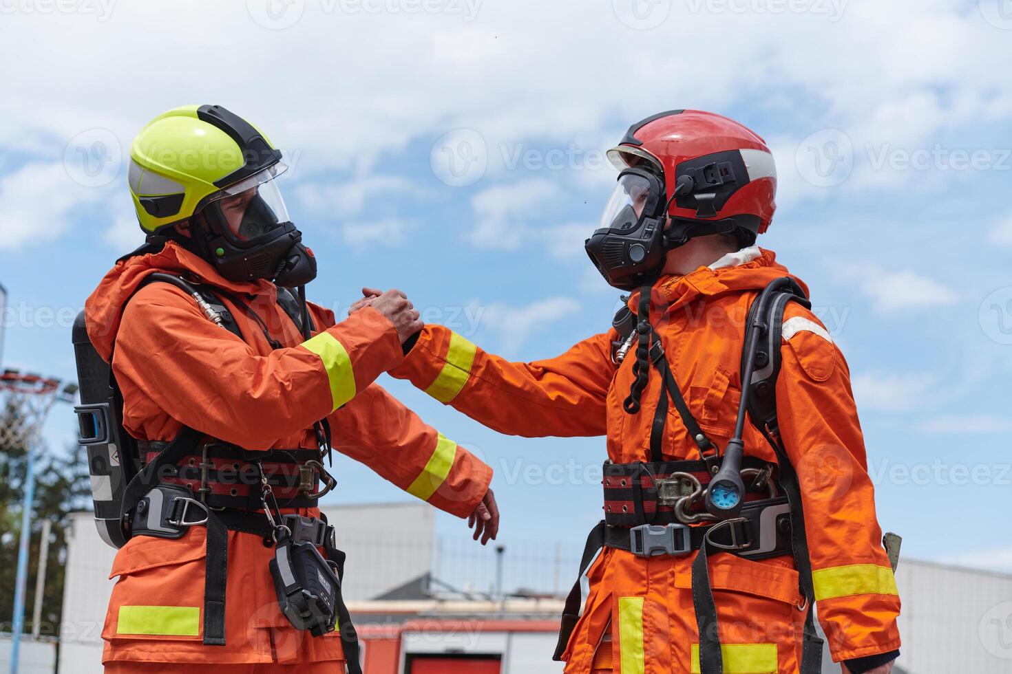 A unified team of firefighters, adorned in their uniforms, engages in a heartfelt celebration marked by triumphant salutes and cheers, embodying the joy and gratitude following the successful photo