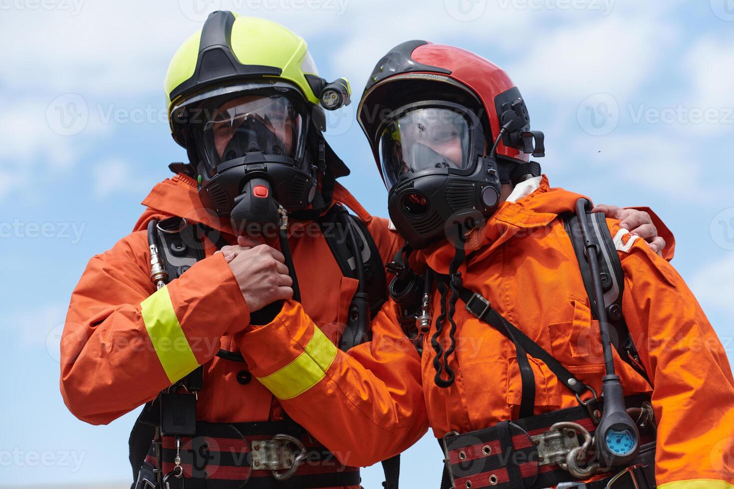 A unified team of firefighters, adorned in their uniforms, engages in a heartfelt celebration marked by triumphant salutes and cheers, embodying the joy and gratitude following the successful photo