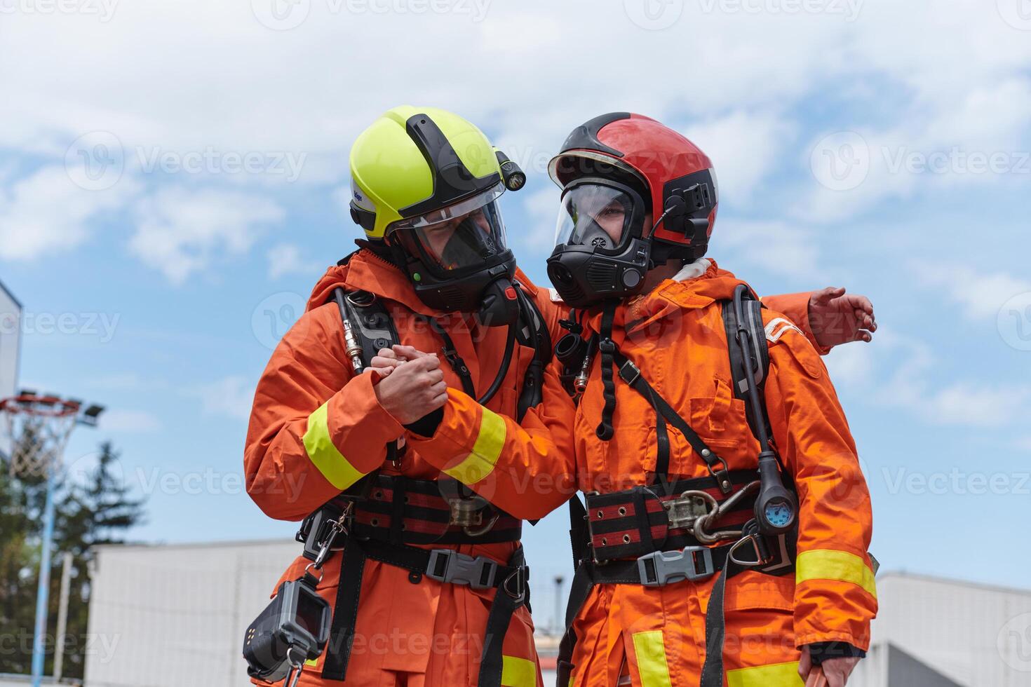 A unified team of firefighters, adorned in their uniforms, engages in a heartfelt celebration marked by triumphant salutes and cheers, embodying the joy and gratitude following the successful photo
